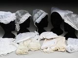 cinq mannequins noirs ornés de dentelle blanche