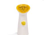 un vase jaune et blanc posé sur une surface blanche