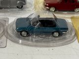 three small toy cars on display on a table