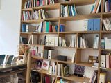 a desk with a laptop and a bookshelf filled with books