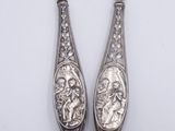 pair of silver spoons with a woman and a man on them