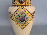 a yellow vase with a colorful design on it