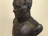 an antique bronze bust of a man with a mohawk on his head