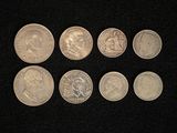 six different types of coins are shown on a black surface