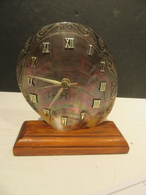 a clock that is on a wooden stand on a table