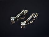 une paire de boucles d'oreilles ornées de diamants sur un fond noir
