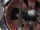 an old helmet with a leather strap on it sitting on top of a table