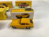 three yellow toy cars sitting on top of a table next to each other