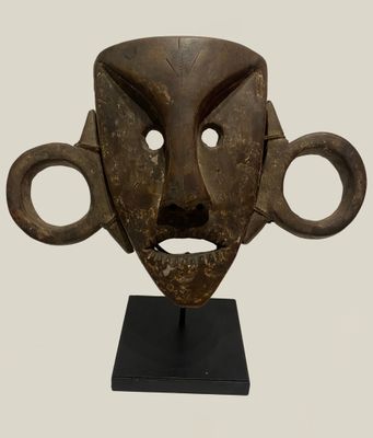 an image of a wooden mask on a stand on a white background