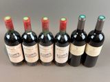 six bottles of wine lined up in a row on a table