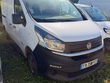 two white vans parked next to each other in a field
