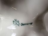 a white porcelain vase with a green design on it