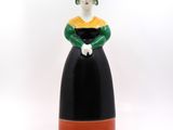 black and green ceramic figurine of a woman wearing a green hat