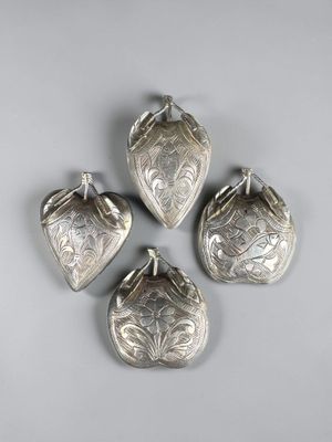 four silver plated bells on a white background