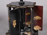 une petite horloge noire et dorée posée sur une table