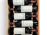 bottles of wine in a wooden box on a white surface