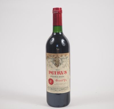 une vieille bouteille de vin rouge posée sur une table blanche