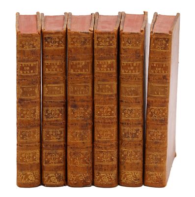 plusieurs vieux livres sont alignés sur une surface blanche