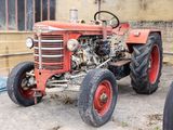 un tracteur rouge garé devant un bâtiment