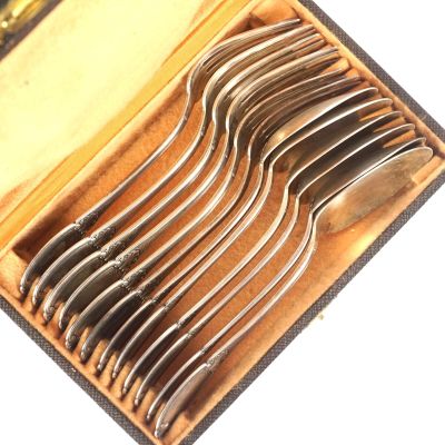 six fourchettes dans un étui posé sur une surface blanche