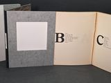 trois livres ouverts posés sur une table