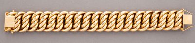 a close up of a gold bracelet on a gray surface
