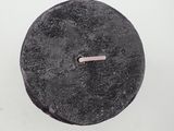 a black object with a pink handle on a white surface