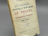 un vieux livre posé sur un support métallique, lui-même posé sur une table