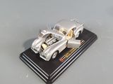 a silver model of a car on a black stand