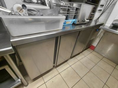 une cuisine équipée d'armoires en acier inoxydable et d'un évier