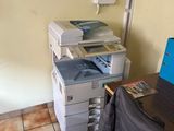 un ordinateur portable posé sur un bureau à côté d'une imprimante
