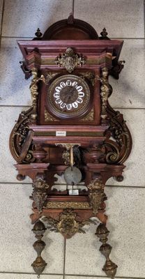 une horloge accrochée au mur et posée par terre