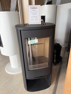 a black stove sitting in a room with a sign on it