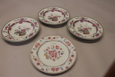 quatre assiettes ornées de motifs floraux sont disposées sur une table