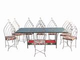 table de salle à manger en fer forgé et six chaises avec des coussins à motifs floraux