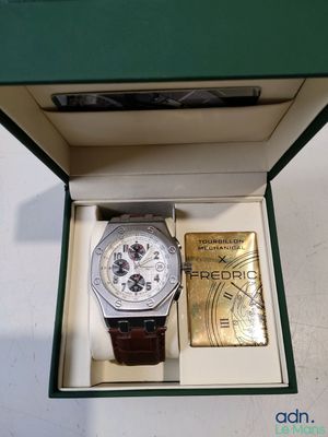 une montre et un lingot d'or dans un coffret