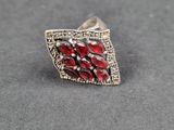a close up of a silver ring with red stones on it