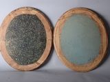 two oval mirrors are sitting on top of a white surface