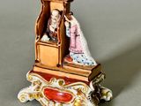 a miniature figurine of a man and a woman sitting in a chair