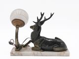 a statue of a deer with a lamp on a marble base