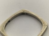 a close up of a silver ring on a white surface