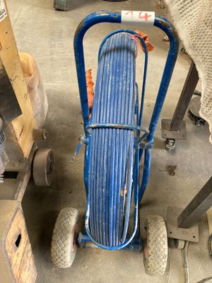 un chariot muni d'un tuyau, dans un garage