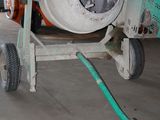cement mixer in a warehouse with a hose attached to it