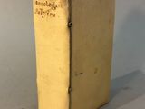 an old book sitting on top of a table next to a white wall