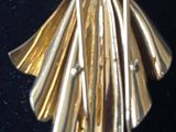 a gold colored brooch with a bird on it