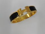 un bracelet noir et doré orné d'une croix