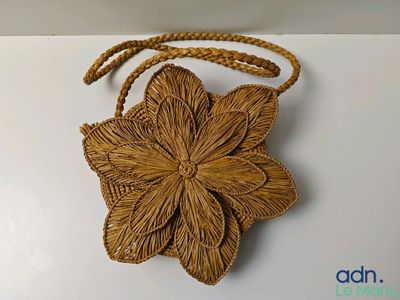 un sac à main marron orné d'une fleur sur un fond blanc