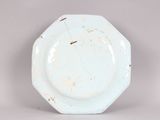 a white plate with rust on it sitting on a table