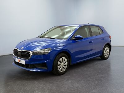 Une voiture bleue est garée dans une pièce au sol noir.