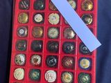 a red box filled with assorted buttons on a table